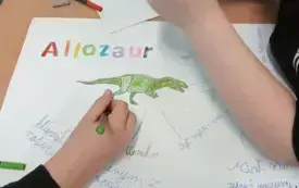 Na zdjęciu uczniowie przegotowują projekt o dinozaurach.