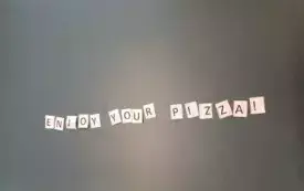 Na zdjeciu napis enjoy jour pizza