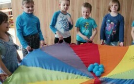 Na zdjęciu uczniowie trzymają chustę.