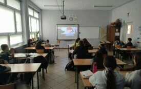 Zdjęcie przedstawia uczni&oacute;w oglądającycj film.
