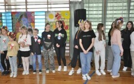 Zdjęcie przedsatwia uczni&oacute;w tańczących poloneza.