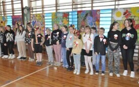 Zdjęcie przedsatwia uczni&oacute;w tańczących poloneza.