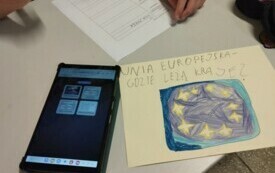Na zdjęciu plakat z flagą EU i tabletem.